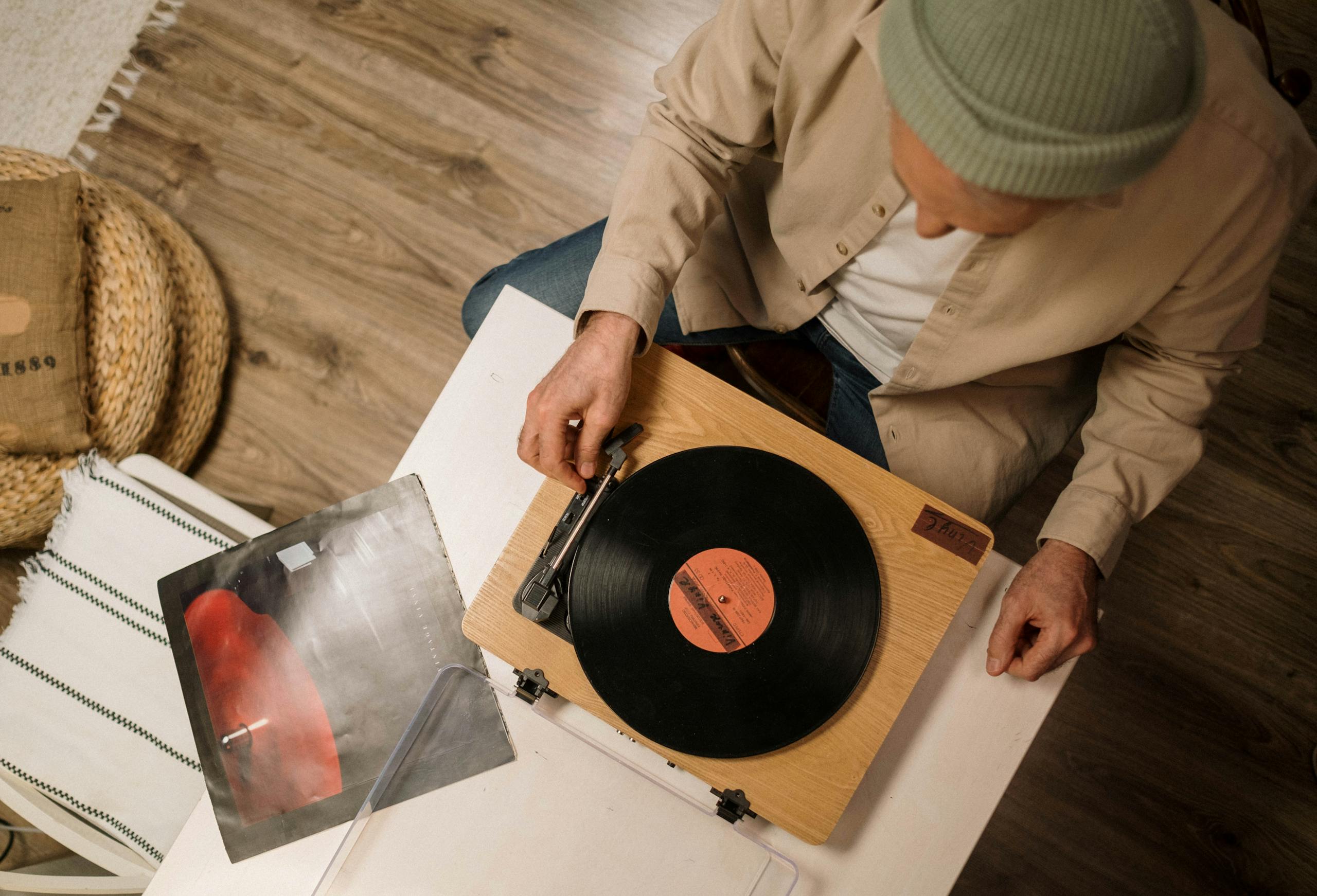 Person Holding Vinyl Record on White Table